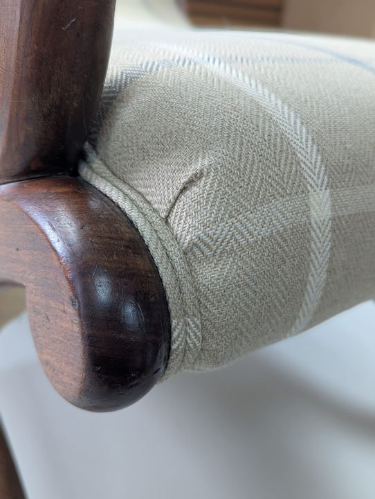 Close-up of the fabric pleated around a carved scroll